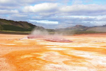 The scorched and destroyed soil around a sulfur lake with gaseous emissions.