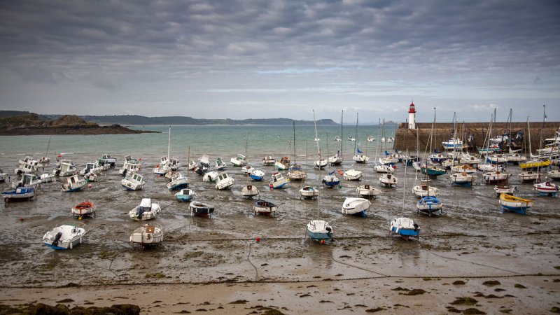 The picturesque French harbour and lighthouse of Erquy in Brittany at low tide. During high tide, the sea level can rise by several metres. (Source: © Dominique VERNIER / stock.adobe.com)