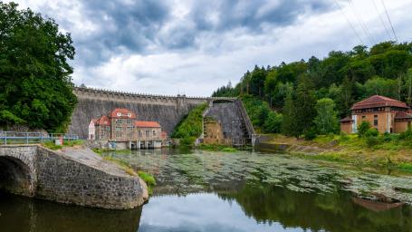 A historic dam with a small hydroelectric power plant. On the right we can see a spillway.