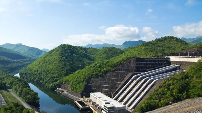 A view from the top of the rockfill dam of the Srinakarin hydroelectric power plant in Kanchanaburi Province, Thailand, on the Kwai Yai River. The penstocks can be seen on the right. (Source: © markuso / stock.adobe.com)