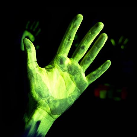 Fluorescence of a left hand under ultraviolet radiation. Henri Becquerel investigated a related phenomenon, phosphorescence, in his experiments with uranium compounds and photographic plates. (Source: © devmarya / stock.adobe.com)