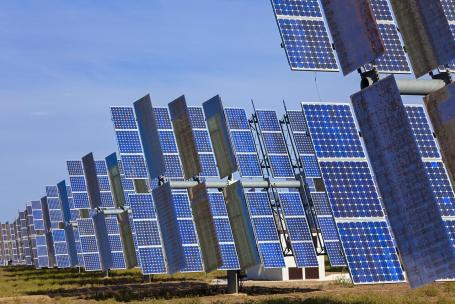 A field of photovoltaic panels with reflective surfaces that increase the amount of sunlight reaching the panels.