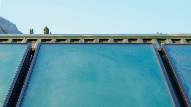 A detail of a flat-plate solar collector on a sheet-metal roof. (Source: © Pavlo Vakhrushev / stock.adobe.com)