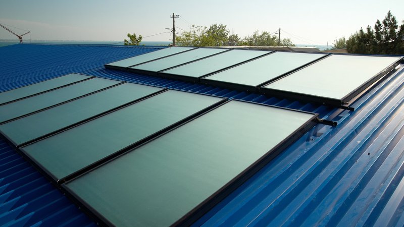 Installing solar collectors on the roof before connecting them to the water circuit. (Source: © Pavlo Vakhrushev / stock.adobe.com)