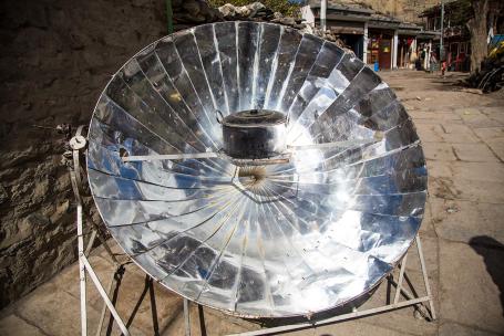 A solar cooker concentrates sunlight onto a focal point, where a cooking vessel can be placed.