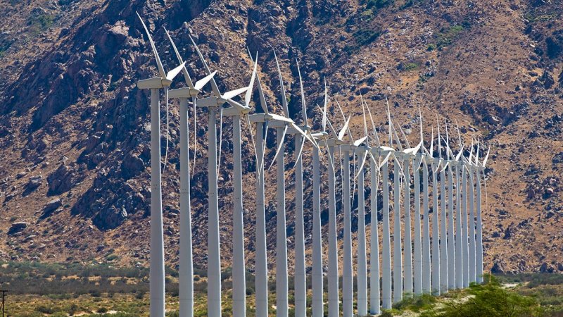 A wind farm in the foothills of a mountain range utilises the favourable local wind conditions. (Source: © SMP / stock.adobe.com)
