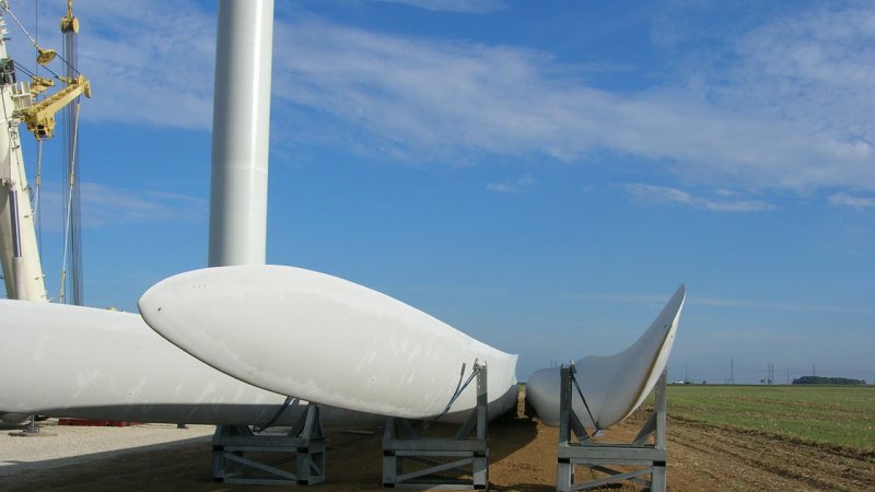 Wind turbine blades temporarily stored at a construction site before installation. (Source: © GERARD DUSSOUBS / stock.adobe.com)